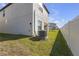 The backyard shows an installed AC unit on a new home with green grass and a white fence at 7229 Spring Snowflake Ave, Tampa, FL 33619