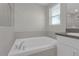 Well-lit bathroom with a soaking tub, granite countertop, and window at 7229 Spring Snowflake Ave, Tampa, FL 33619