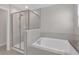 Bright bathroom featuring a glass-enclosed shower and a relaxing soaking tub at 7229 Spring Snowflake Ave, Tampa, FL 33619