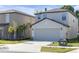 Two-story home with a two-car garage, concrete driveway, and well-maintained lawn at 7229 Spring Snowflake Ave, Tampa, FL 33619