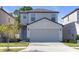 Charming two-story home featuring a two-car garage and well-maintained lawn and landscaping at 7229 Spring Snowflake Ave, Tampa, FL 33619
