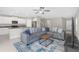 Spacious living room with gray sofa, an open layout, and views into the modern kitchen at 7229 Spring Snowflake Ave, Tampa, FL 33619