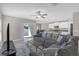 Spacious living room with gray sofa, an open layout, and sliding door to backyard at 7229 Spring Snowflake Ave, Tampa, FL 33619