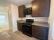 Kitchen featuring dark cabinets, modern appliances, granite counters, and wood-look flooring at 7529 Pitch Pine Cir # 190, Tampa, FL 33617