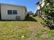 Back view of a charming house featuring a lush lawn, adjacent buildings and ample space for outdoor activities at 842 180Th E Ave, Redington Shores, FL 33708