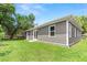 Spacious backyard with a well-maintained lawn and exterior view of the house at 9303 N 19Th St, Tampa, FL 33612