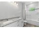 Bright bathroom featuring a double vanity with granite countertops and a shower-tub combination at 9303 N 19Th St, Tampa, FL 33612