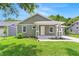 Charming home with a covered front porch, green siding, and landscaped front yard at 9303 N 19Th St, Tampa, FL 33612