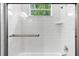 Modern tiled shower featuring a glass door and window at 9303 N 19Th St, Tampa, FL 33612