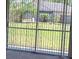 View of a green backyard through sliding glass doors with screen and backyard fence at 2105 Haydon Ct, Brandon, FL 33511
