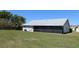 View of the home's backyard featuring a well-maintained lawn and screened-in porch at 2105 Haydon Ct, Brandon, FL 33511