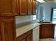 Kitchen corner with wood cabinets, white dishwasher, and sink with light countertops at 2105 Haydon Ct, Brandon, FL 33511