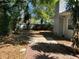 Lush backyard featuring mature trees, a mix of pavers and mulch, and partial views of the home's exterior at 10126 Bahama Ct, Seminole, FL 33776