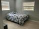 Cozy bedroom featuring a comfortable bed, neutral walls, and natural light from two windows at 10126 Bahama Ct, Seminole, FL 33776