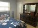Bedroom featuring a large dresser with a mirror, a comfortable bed, and natural light at 10126 Bahama Ct, Seminole, FL 33776