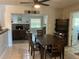 Open-concept dining room with a dark wood table, chairs, and a view of the living room and fireplace at 10126 Bahama Ct, Seminole, FL 33776