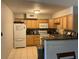 Traditional kitchen with light wood cabinets, tile floors, white appliances, and ample counter space at 10126 Bahama Ct, Seminole, FL 33776