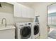 Clean laundry area with an LG washer and dryer, sink, and storage cabinets, complemented by neutral decor at 1035 Royal Pass Rd, Tampa, FL 33602