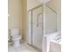 Clean bathroom featuring a glass-enclosed shower with white tile surround and new toilet at 10641 Firebrick Ct, Trinity, FL 34655