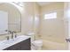 Stylist bathroom features black vanity, bathtub and shower combination, and bright window at 10641 Firebrick Ct, Trinity, FL 34655