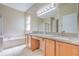 Bright bathroom featuring a double vanity with granite countertop, tub, and separate glass-enclosed shower at 10641 Firebrick Ct, Trinity, FL 34655