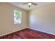 Cozy bedroom featuring rich hardwood floors, neutral walls, ceiling fan and a bright window at 10641 Firebrick Ct, Trinity, FL 34655