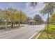 Gated community entrance with a guard house, mature trees, and well-maintained landscaping at 10641 Firebrick Ct, Trinity, FL 34655