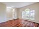 Bright living room featuring hardwood floors and a large arched window for ample natural light at 10641 Firebrick Ct, Trinity, FL 34655
