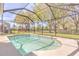 Enjoy the outdoors in the screened pool area, featuring tiled trim and view of the manicured backyard at 10641 Firebrick Ct, Trinity, FL 34655