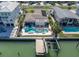 Aerial shot of a waterfront home with a boat dock, lush landscaping, and a sparkling blue pool and jacuzzi at 11125 7Th E St, Treasure Island, FL 33706
