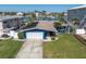 Charming blue home with a well-manicured lawn and a white garage door at 11125 7Th E St, Treasure Island, FL 33706