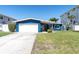 Exterior shot of a well maintained blue home with a green lawn at 11125 7Th E St, Treasure Island, FL 33706