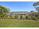 Wide shot of the backyard, showing a screened-in pool area with a well-manicured lawn at 13553 Landers Dr, Hudson, FL 34667