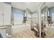 Bathroom boasts tub, frameless glass shower and wood-look tile floors at 13553 Landers Dr, Hudson, FL 34667