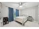 Neutral bedroom featuring a ceiling fan, carpet, and window with blue curtains at 13553 Landers Dr, Hudson, FL 34667