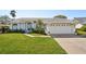 Charming one-story home with lush lawn, mature landscaping and a driveway leading to an attached two-car garage at 13553 Landers Dr, Hudson, FL 34667