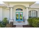 Inviting front entrance with double doors, decorative columns, and meticulously kept landscaping at 13553 Landers Dr, Hudson, FL 34667