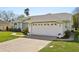 Spacious two-car garage featuring decorative windows, a concrete driveway, and neat landscaping at 13553 Landers Dr, Hudson, FL 34667