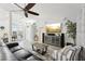 Inviting living room with high ceilings, large ceiling fan, stylish furniture, and entertainment center at 13553 Landers Dr, Hudson, FL 34667