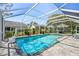 Sparkling pool enclosed with a screen, offering a clear view of the backyard and surrounding greenery at 13553 Landers Dr, Hudson, FL 34667