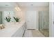 Modern bathroom featuring double sinks, quartz countertops, a glass-enclosed shower, and neutral tones at 16715 Shell Bay Dr, Land O Lakes, FL 34638