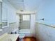 Bathroom featuring tiled shower with a glass block window and a sink with a mirror at 1800 New Hampshire Ne Ave, St Petersburg, FL 33703