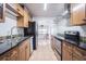 Kitchen featuring wooden cabinets, black countertops, tile backsplash, and stainless steel appliances at 1807 23Rd N Ave, St Petersburg, FL 33713