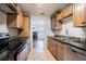 Kitchen with wooden cabinets, black countertops, stainless steel appliances, and colorful backsplash at 1807 23Rd N Ave, St Petersburg, FL 33713