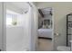 All-white bathroom with shower and view to bedroom featuring tiled tub, shower curtain and natural light at 2096 Church Creek Pt, Largo, FL 33774