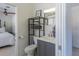 Tastefully designed bathroom offering a gray vanity, storage shelves and a glimpse into a cozy bedroom at 2096 Church Creek Pt, Largo, FL 33774