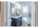 Bathroom vanity featuring gray cabinets, marble countertops, and a framed mirror at 2096 Church Creek Pt, Largo, FL 33774