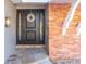 Elegant front door with glass sidelights and decorative wreath, set against a charming brick wall at 2096 Church Creek Pt, Largo, FL 33774
