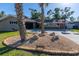 View of the landscaped front yard with rock features and palm trees, providing a serene outdoor space at 2096 Church Creek Pt, Largo, FL 33774