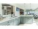 Bright kitchen with gray cabinets, white countertops, and modern fixtures, open to a sunroom with ample natural light at 2096 Church Creek Pt, Largo, FL 33774